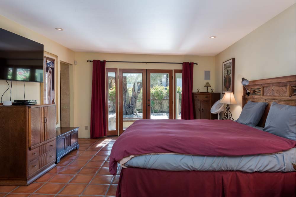 barber using styling spray on young man with black hair, short on sides and long in a quiff on top